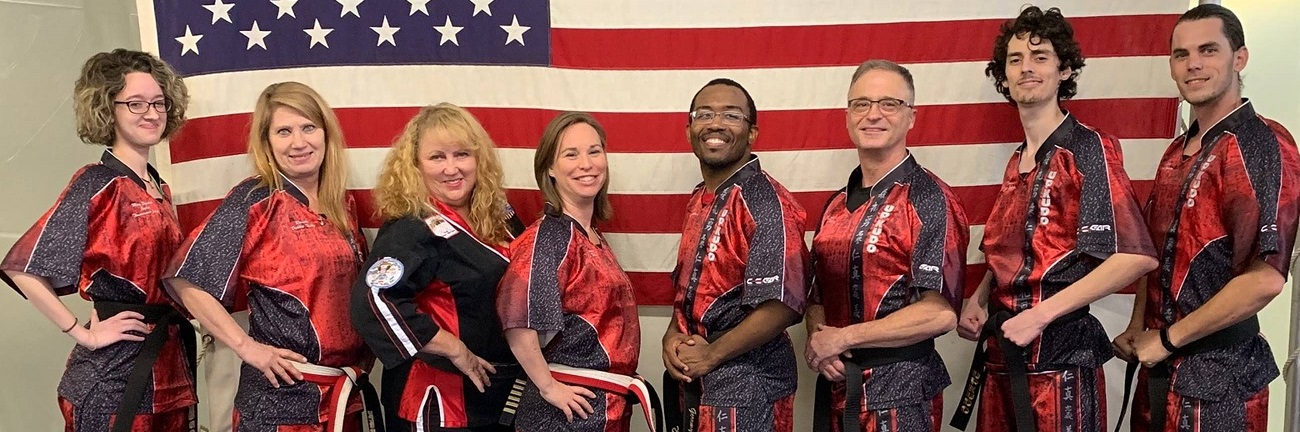 UPKUDO Karate students standing in a line in front of an American flag