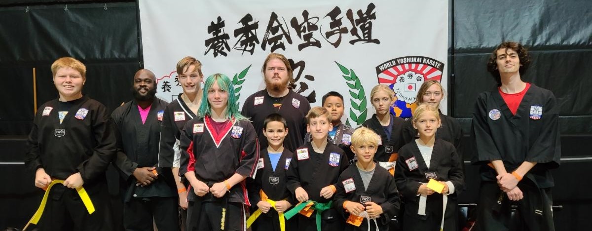Group photo of participants in front of tournament banner